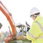 Supervisor,Using,Walkie-talkie,At,Construction,Site,Against,Clear,Sky