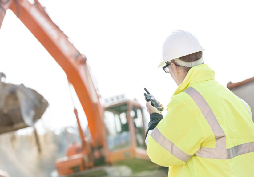 Supervisor,Using,Walkie-talkie,At,Construction,Site,Against,Clear,Sky